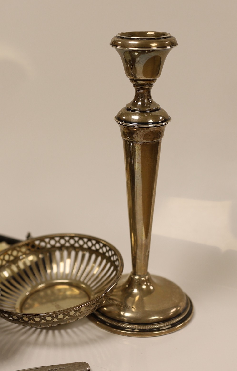 A pair of George V silver mounted candlesticks, weighted, 19.7cm, a silver vase, two pierced silver small dishes, a silver mounted penknife, George III silver spoon, a silver pepperette, pair of silver tongs, silver salt